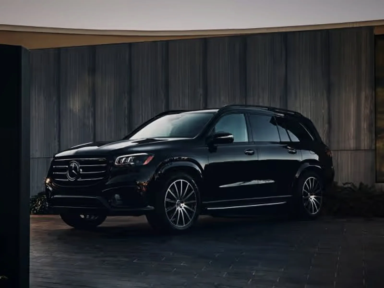 Schwarzer Mercedes GLS vor einer dunklen Fassade